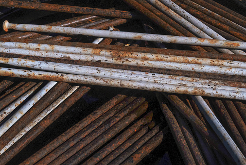 overhead close up of a retail display of a stack of old and rusty steel curtain rods, for sale at a junkyard, Long Island, New York State