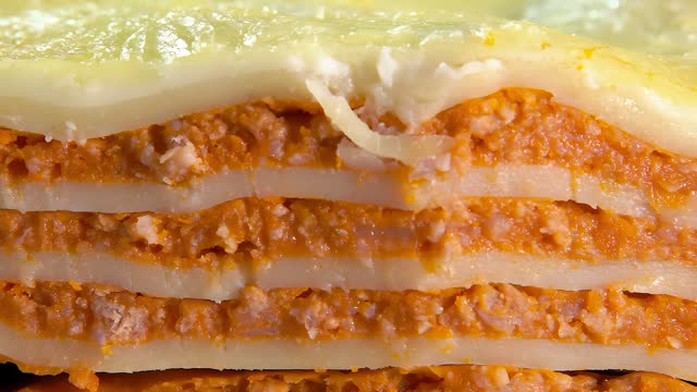 Knife cuts off a piece of the Italian lasagna