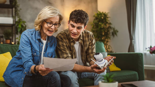 istock Mother and son adjust and install home cctv video surveillance camera 2094733597