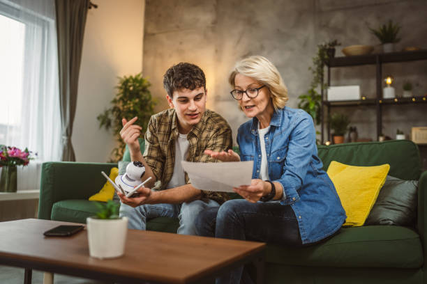 istock Mother and son adjust and install home cctv video surveillance camera 2094740916