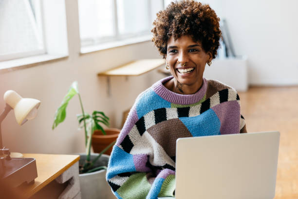 istock Smiling woman working on laptop in a co-working space 2094764532
