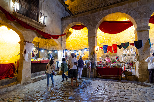 5th September, 2014 - Ibiza Town, Spain: The streets of Ibiza's Old Town, Dalt Vila, come alive during the Medieval Festival, transforming the historic area into a vibrant tableau of the past. Tourists, shoppers, and stall merchants mingle among the colorful stalls, showcasing everything from traditional crafts to local delicacies, against the backdrop of the ancient city's charming architecture. This annual event not only celebrates the rich history of Ibiza but also brings together people from all walks of life to partake in the festivities.