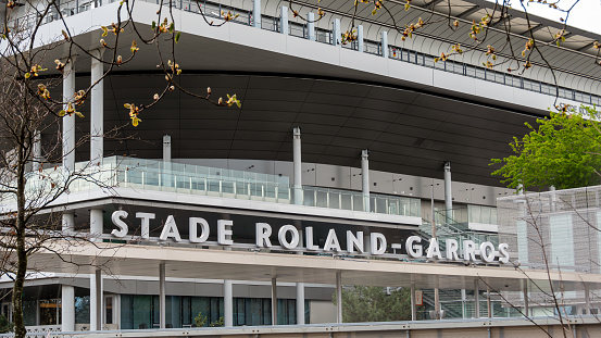 Paris, France - March 18, 2024: Entrance to the Roland-Garros tennis stadium with the center court in the background. The Roland-Garros stadium hosts the French Open tennis tournament every year