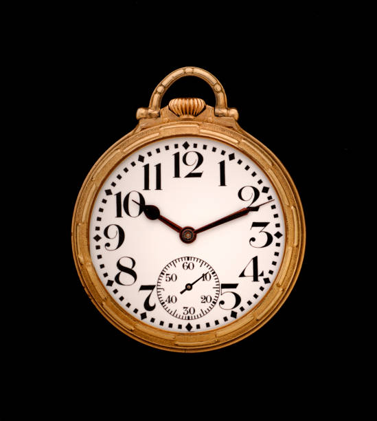 Closeup of a mid century pocket watch on a whitewashed wood background.