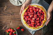 Woman preparing strawberry galette or open strawberry pie