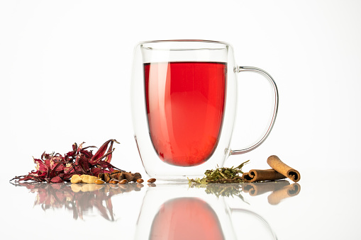 Fruit red tea with wild berries in glass cup, in forest, on bright background. summer season. concept of tea time and summer. soft selective focus.