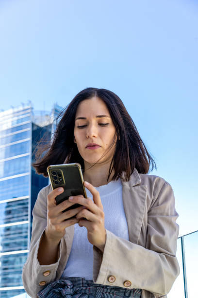 istock Low-angle view of a beautiful woman writing a message on her smartphone. Copy space. 2094857209