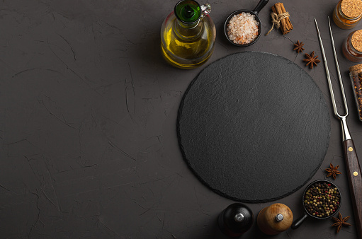 Banner Black stone plate with spices and herbs. Concept cooking. Free space for your text.