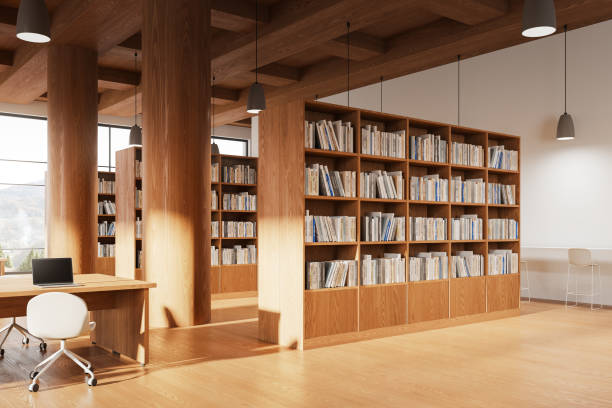 istock Wooden library interior with workspace and laptop, bookshelf and window 2094888872