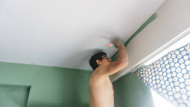 istock A man with glasses painting a wall 2094910467