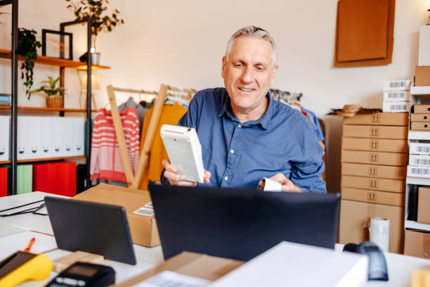 istock Man packing goods and preparing it for delivery service using laptop 2094912076