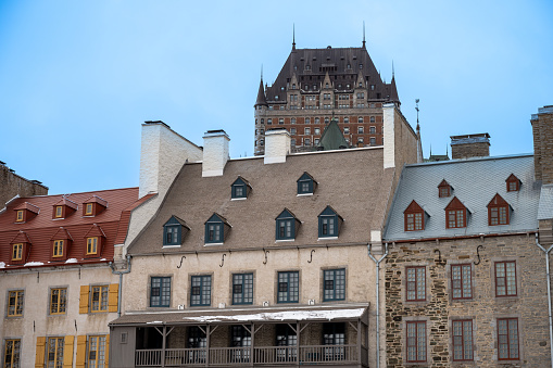Facade of Old houses in Quebec city with Chateau Frontenac in background on a clear sky during daytime