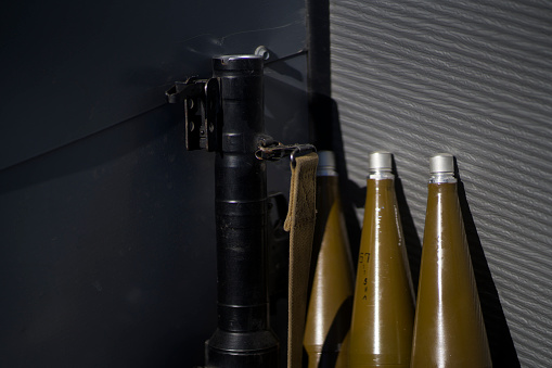 Artillery shells and a machine gun stand against the background of a gray wall, a banner with army militaristic weapons, closeup view.