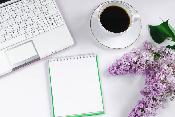 istock Spring flatlay. Notepad, laptop, lilac flowers and cup of coffee on light background. 2094933835