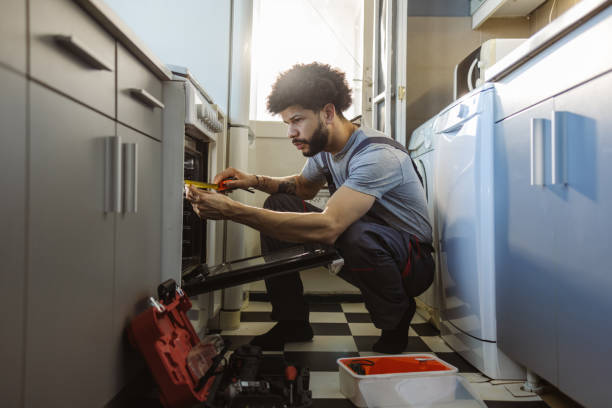 istock Young Latin worker repairing the oven in the kitchen 2094974942