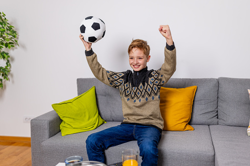The match day excitement is palpable as a young boy watches a soccer game on TV, his early fandom blossoming with every play