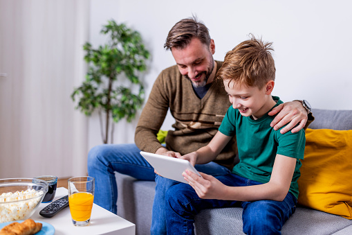 Embracing the portability of a digital tablet, a father and son make every corner of their home a venue for watching their cherished soccer games together
