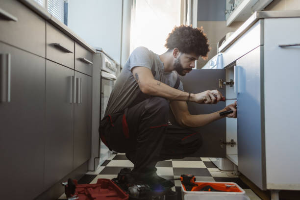 istock Hispanic young plumber repairs a broken water pipe under the sink 2094993444