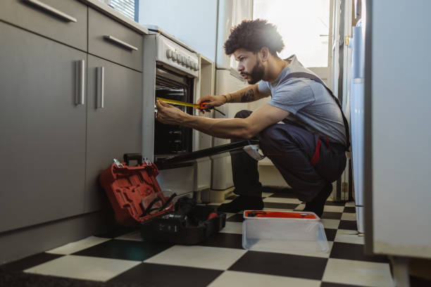 istock Young Latin worker repairing the oven in the kitchen 2095039532