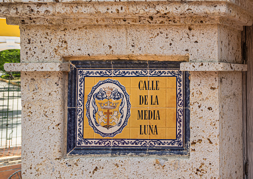 Cartagena, Colombia - July 25, 2023: Closeup, Calle de Media Luna historical sign on corner of Hotel Londres building at intersection Calle 30 and Carrera 9.