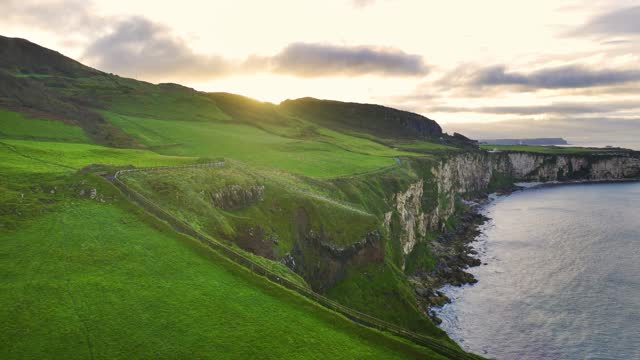 Aerial view of sea and cliff in Northern Ireland, Tall Cliffs Covered with Greenery Near the Beach in Northern Ireland, Bay towards Carrick-A-Rede coastline in Northern Ireland, Aerial view of natural cliffs in Northern Ireland