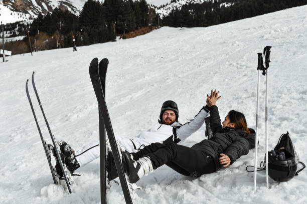 istock High Five For Skiing Couple Lying Down In The Snow 2095090782