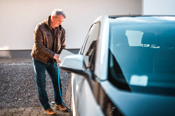 istock Senior Man Charges His Electric Vehicle in Daylight 2095136361