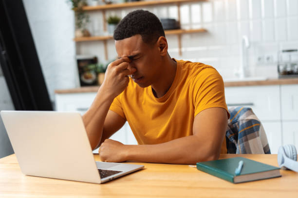istock Depressed sad Latin man working at home, using laptop, eyes closed, having migraine, having bad news 2095247753