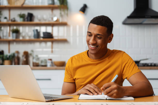 istock Handsome African American man, freelancer working, using laptop, taking notes, attractive writer 2095247756