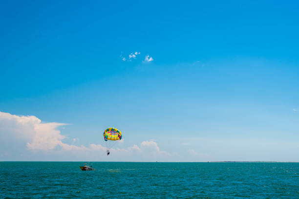 Parasailing on Aegean sea, town of Kuşadası in Turkey on a sunny summer day, View Of Kusadasi Skyline At Aegean Coast, Turkey.