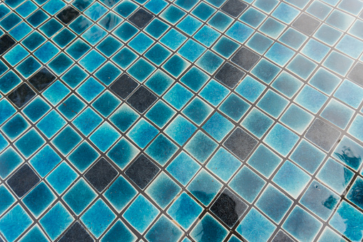 Tiles in swimming pool in summer, blurred background