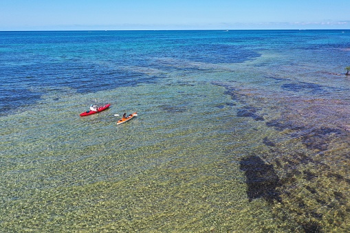 Key Biscayne, Florida - May 4, 2020: Young couple enjoys afternoon of kayaking on calm, clear water of Bear Cut on sunny May afternoon.