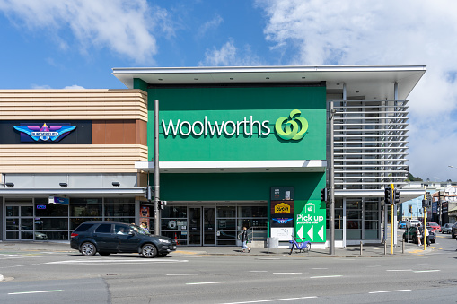 Wellington, New Zealand - February 10, 2024: Close-up of Woolworths sign on the building in Wellington, New Zealand. Woolworths Supermarkets is an Australian chain of supermarkets and grocery stores.