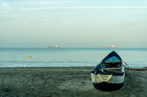 Artisanal fishing boat on the beach watching the sunset in the sea
