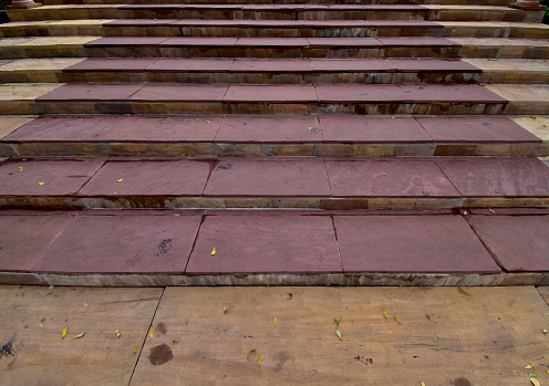 Closeup of The stair steps are made of red and brown granite background.