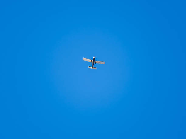 Small ultralight airplane with overhead wing and single propeller flying in sunset sky. Such aircraft are used for recreational, sport and flight training.