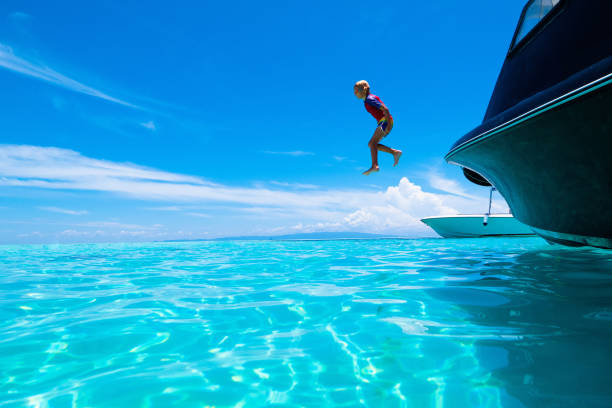 child jumping into sea water. yacht vacation. - clear sky water sports and fitness yacht fotografías e imágenes de stock