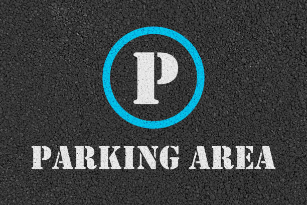 Parking sign and words parking area on road.