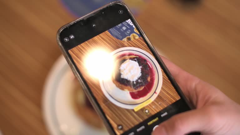 Food Blogger Taking Picture Of Vegan pancakes For Breakfast with blue berries Using Smartphone