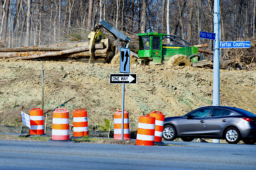 Fairfax, Virginia, USA - March 14, 2024: Heavy equipment drags cut trees to clear room for a new interchange at the intersection of the Fairfax County Parkway (Route 286) and Popes Head Road (Route 654) in Fairfax County.