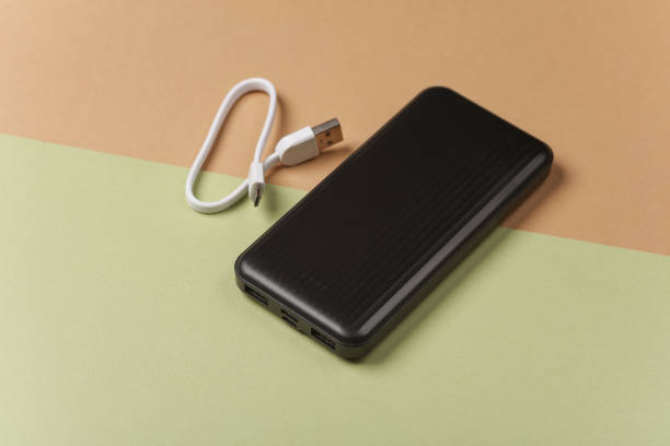 istock Black power bank with cable on green beige background 2095711672