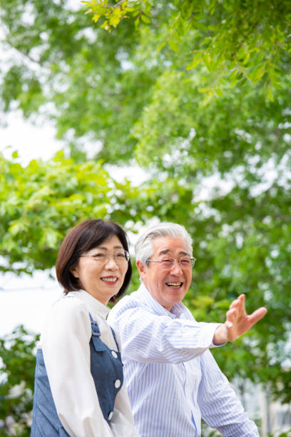 istock A middle-aged Japanese couple smiling and talking on a park bench 2095712186