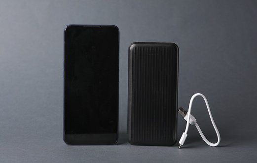 Smartphone with power bank on a dark gray background