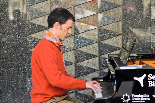 Bilbao, Spain - abril 4, 2014: A man plays a grand piano during music initiative Bilbao se llena de pianos consisting of seven grand pianos spread through the city.