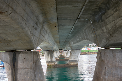 The Villa de Bouzas bridge in Vigo seen from below with its symmetrical view of each of its columns and with the high tide