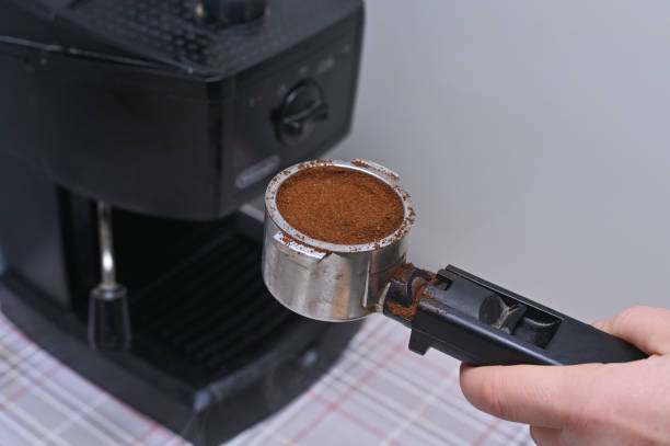 istock a woman's hand puts coffee in the coffee machine 2095797896