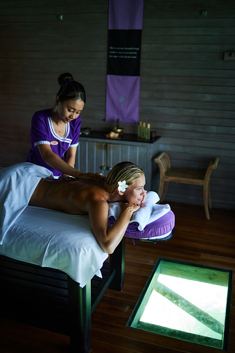 Smiling woman enjoying in a relaxing back massage at the spa.
