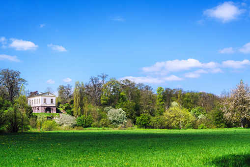 Weimar, Germany - May 3, 2023:  A beautiful countryside villa in Weimar, Germany surrounded by lush greenery and a clear blue sky. Perfect depiction of serene European living.