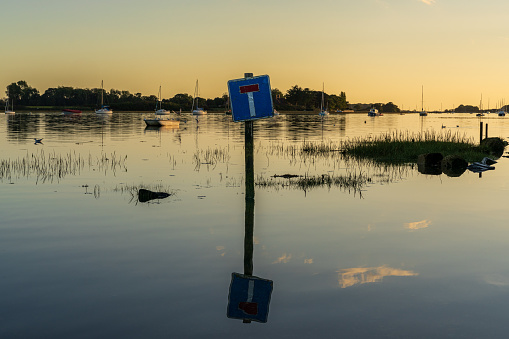 Bosham, West Sussex, England, UK - October 02, 2022: A flooded road and a dead end sign in the evening