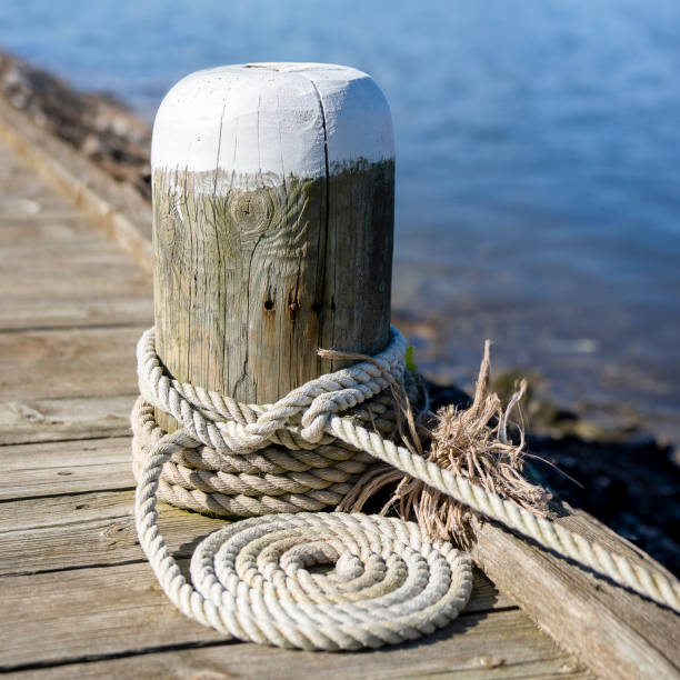 istock Wooden bollard with rolled-up boat rope 2095841348